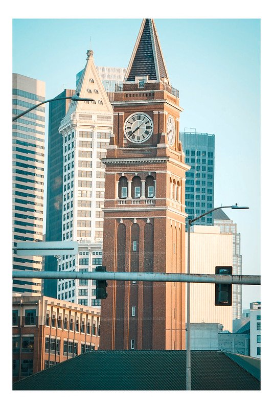 Brick clock tower among downtown buildings