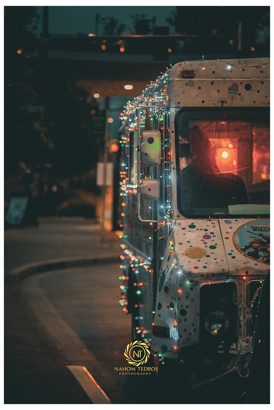 Food truck at night covered in colorful string lights