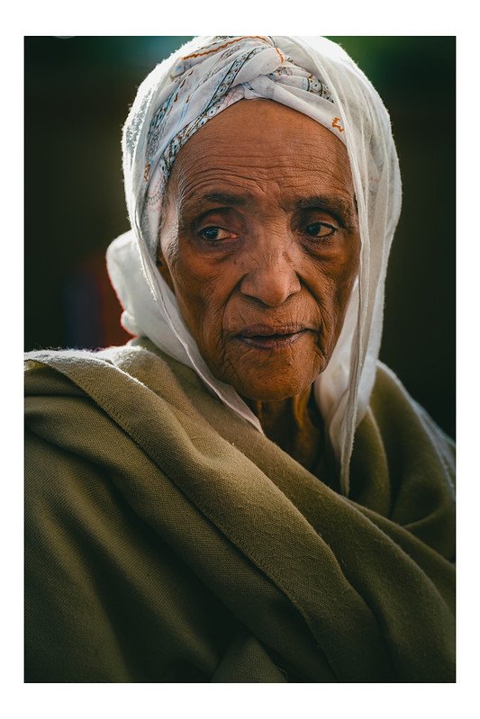 Close portrait of an elder in a white headscarf