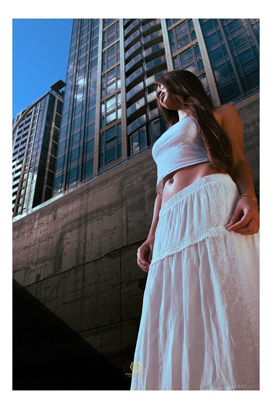 Portrait session in white against downtown towers