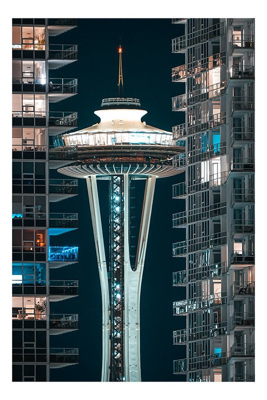 Space Needle illuminated at night between two towers